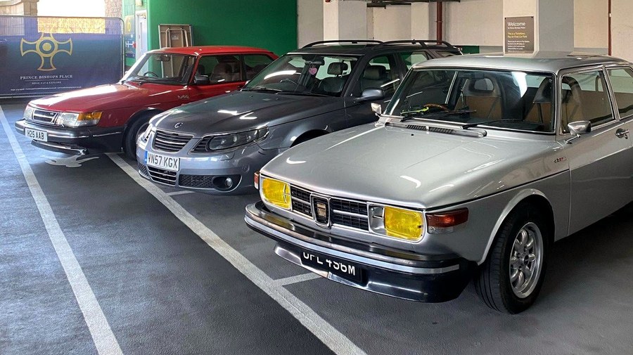 A mixed lineup of Saabs indoors.